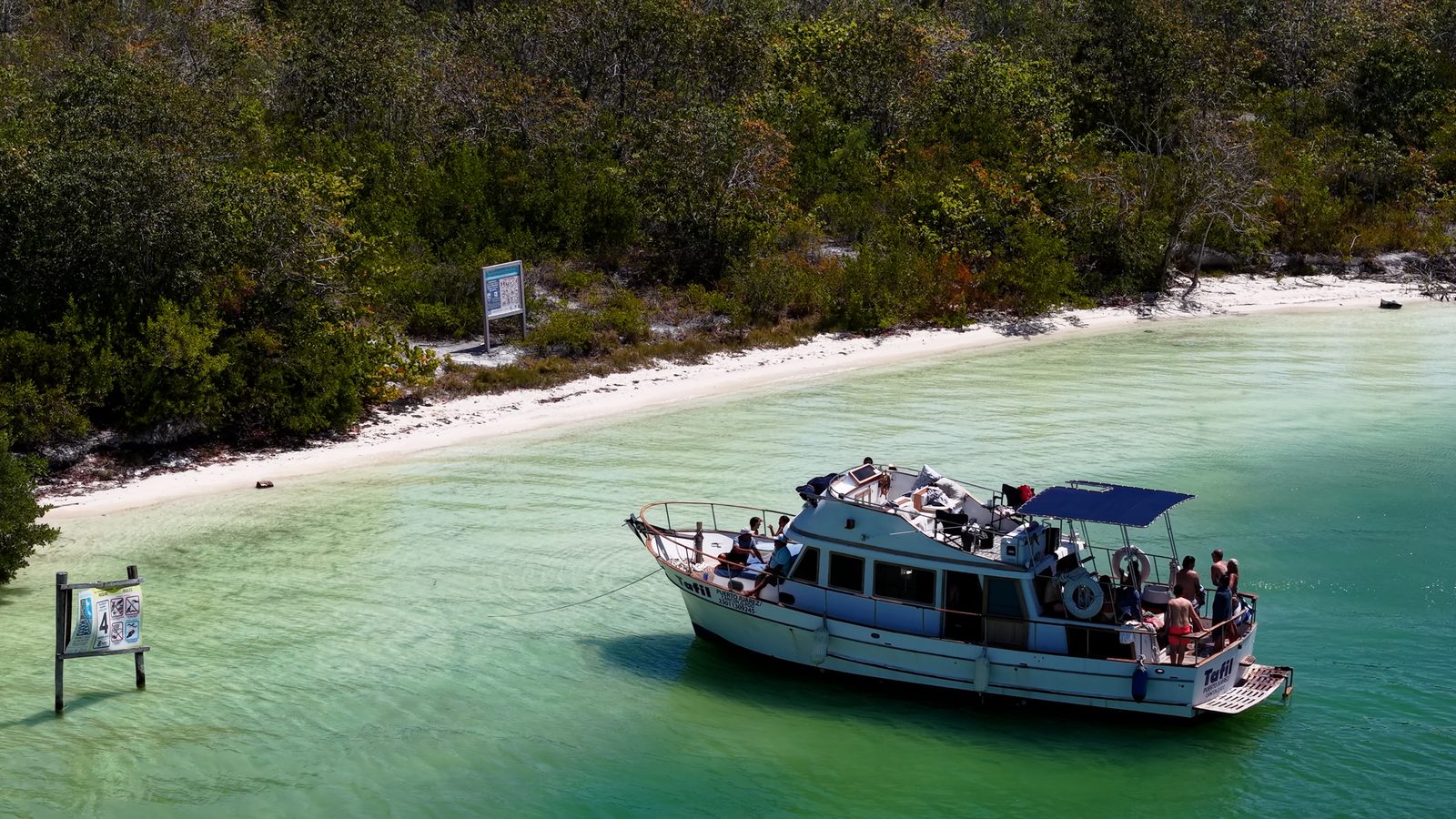 The Tafil moored at Playa Conchitas beach with guests swimming