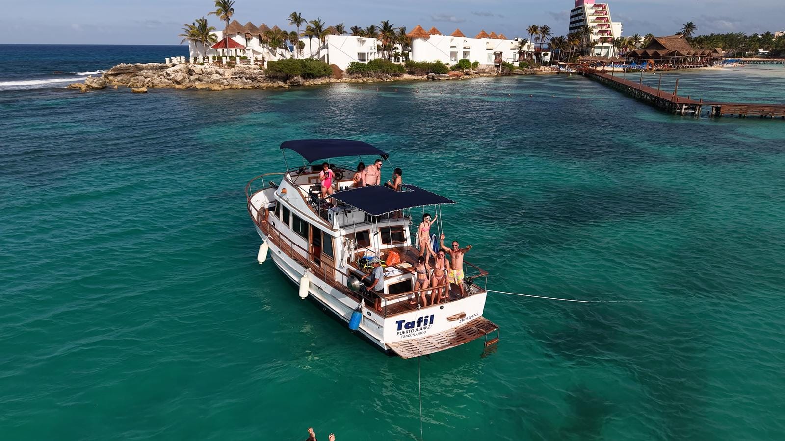 The Tafil anchored off Punta Norte with guests aboard and the Isla Mujeres shoreline behind