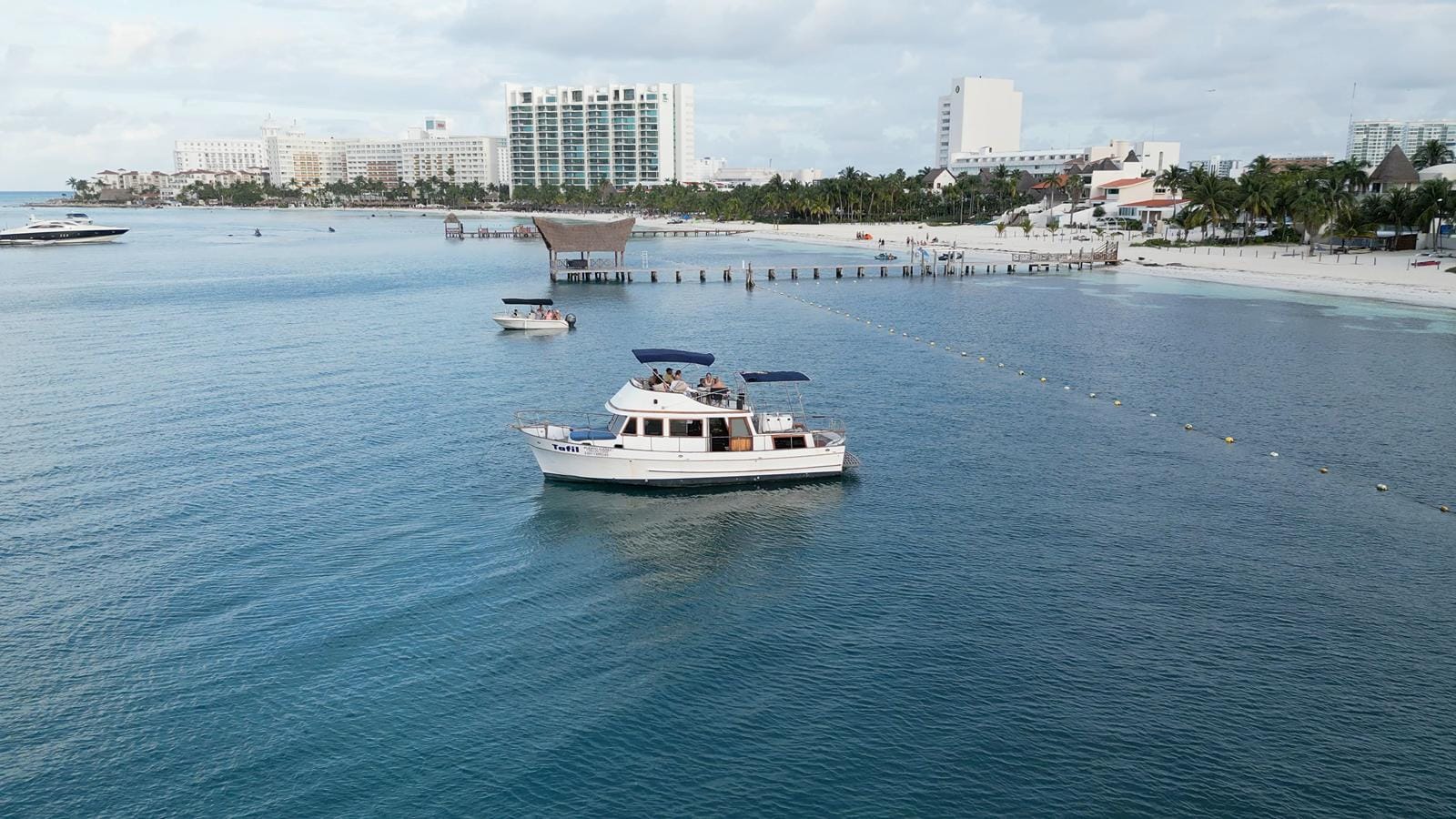 The Tafil cruising the calm bay with the Cancún hotel towers behind
