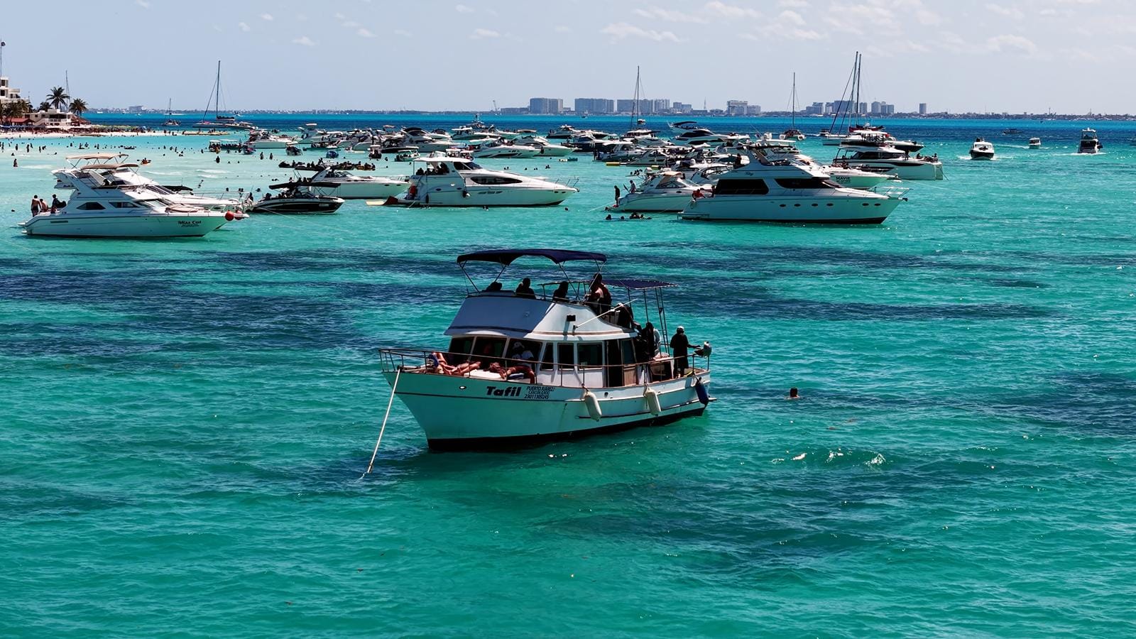 The Tafil anchored among dozens of yachts off Playa Norte with the Cancún skyline on the horizon