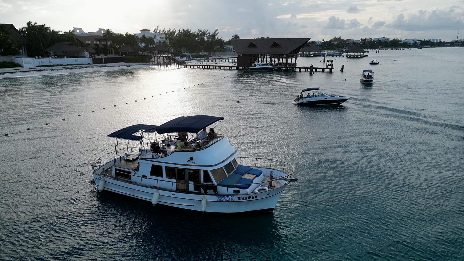 Guests aboard the Tafil at golden hour off the Hotel Zone coastline