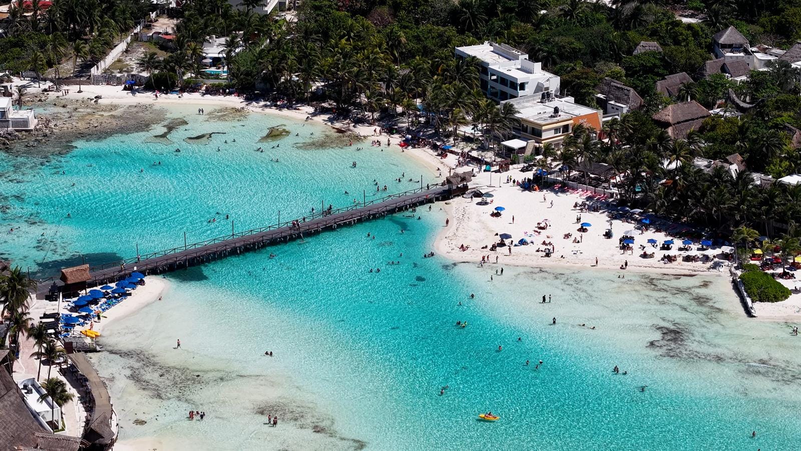 Aerial view of Playa Norte beach and pier with swimmers in the shallow turquoise water
