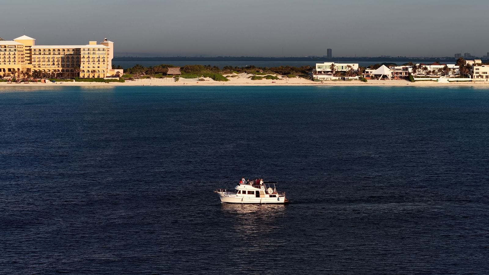 The Tafil at sea with the Cancún Hotel Zone skyline at sunset