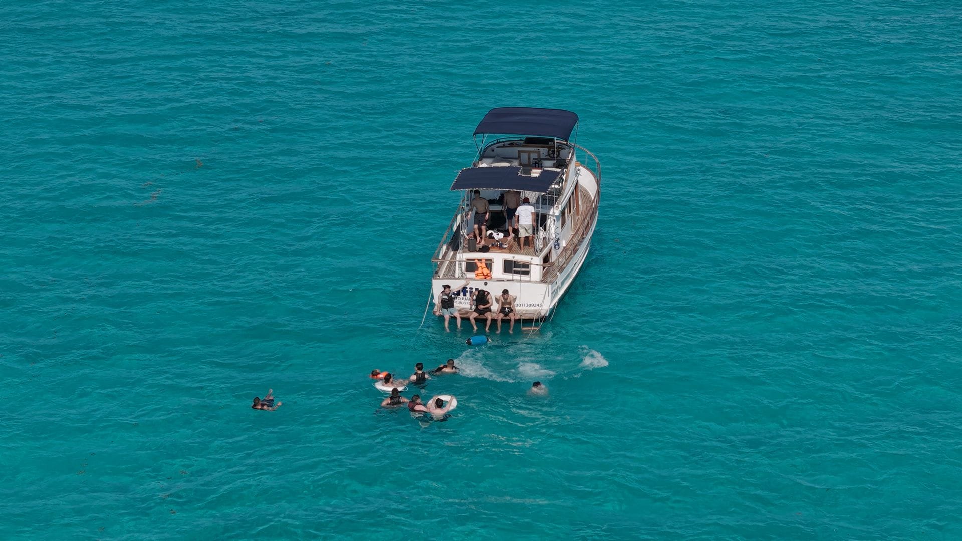 Drone view of the Tafil anchored at the Arenales with swimmers around the boat