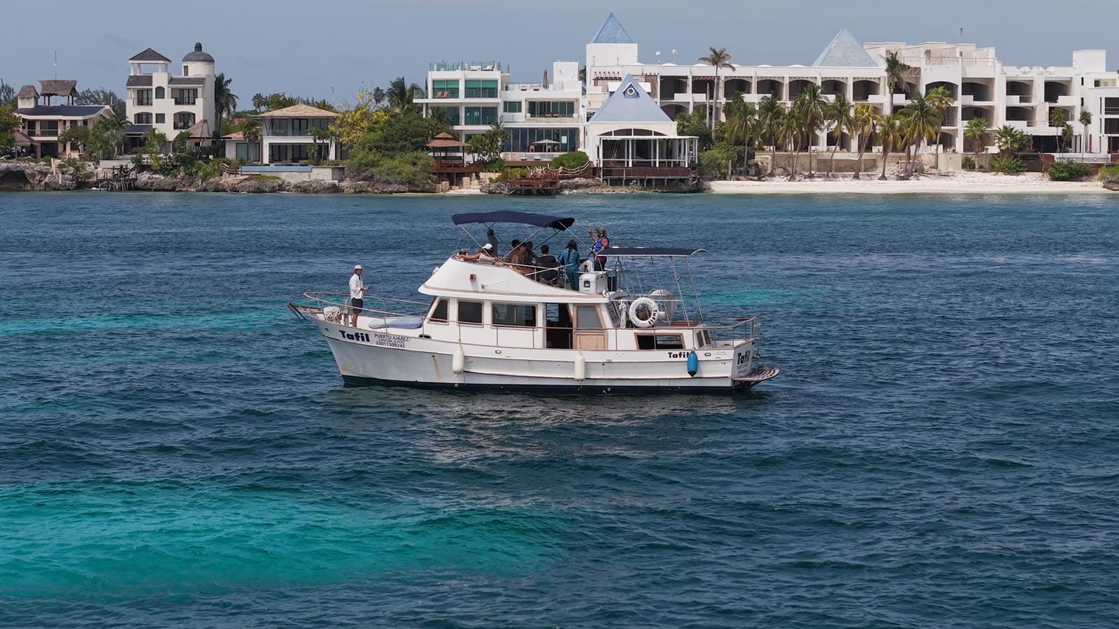 The Tafil at water level with the Isla Mujeres shoreline and palms behind