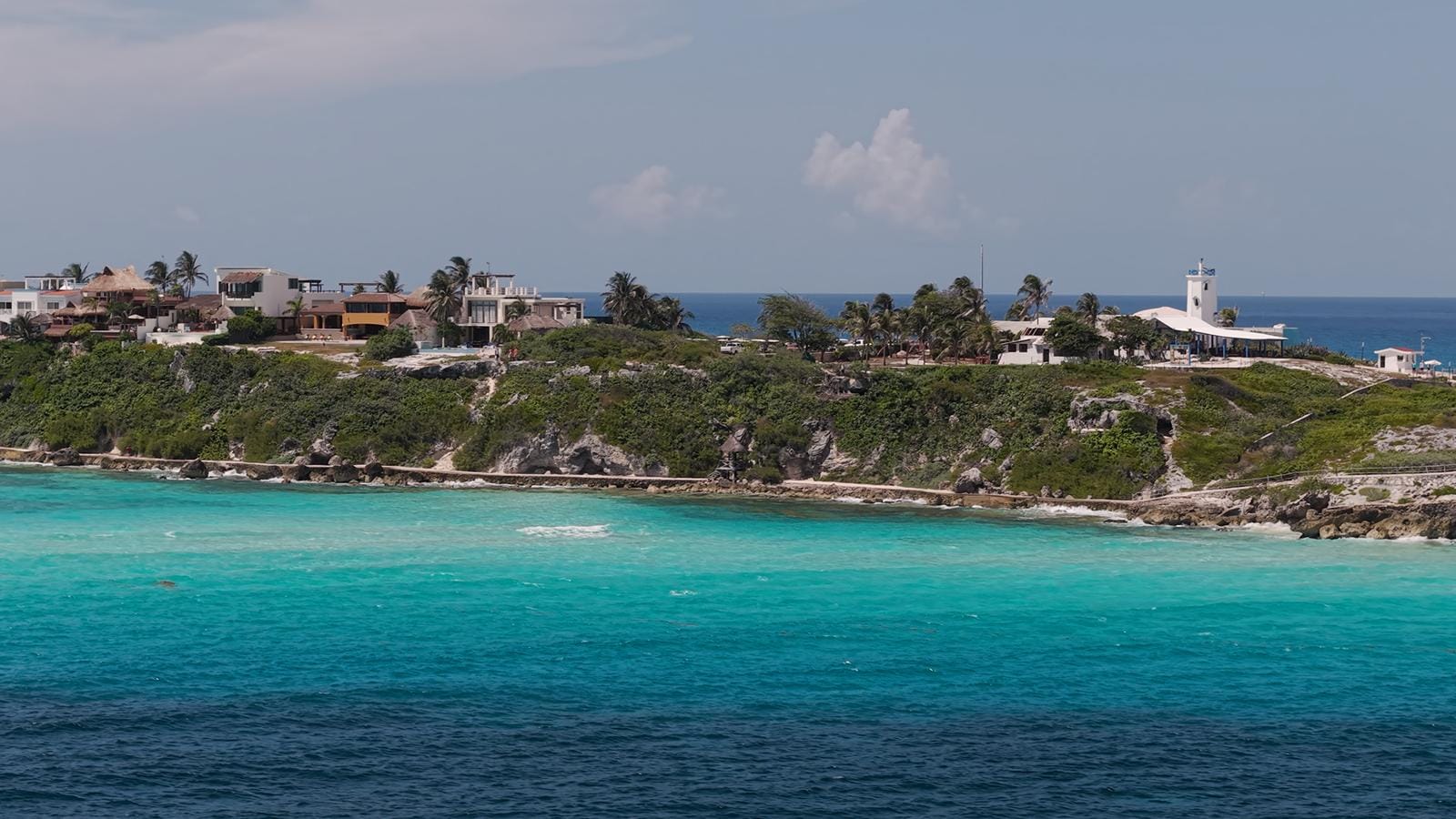 Aerial view of the Isla Mujeres shoreline with cliffs and turquoise shallows