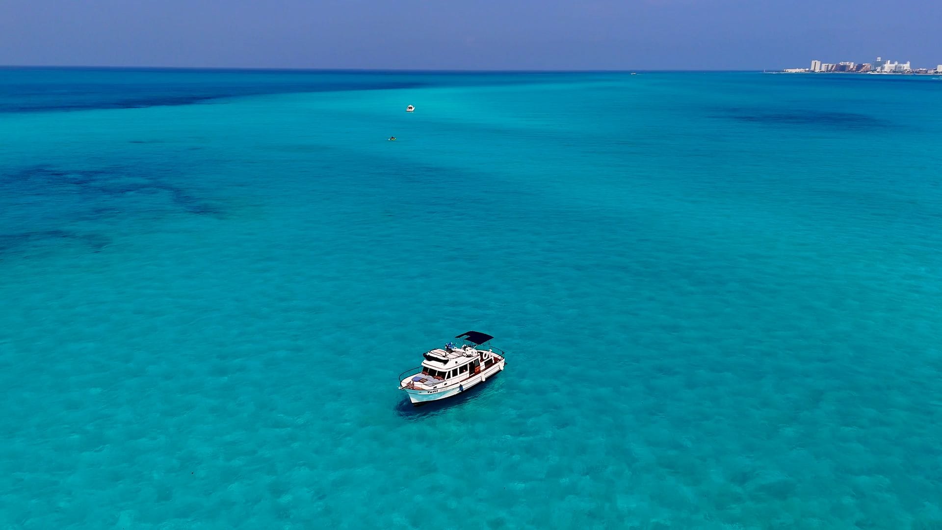 Aerial view of the Tafil crossing the deep blue and turquoise waters of Cancún Bay