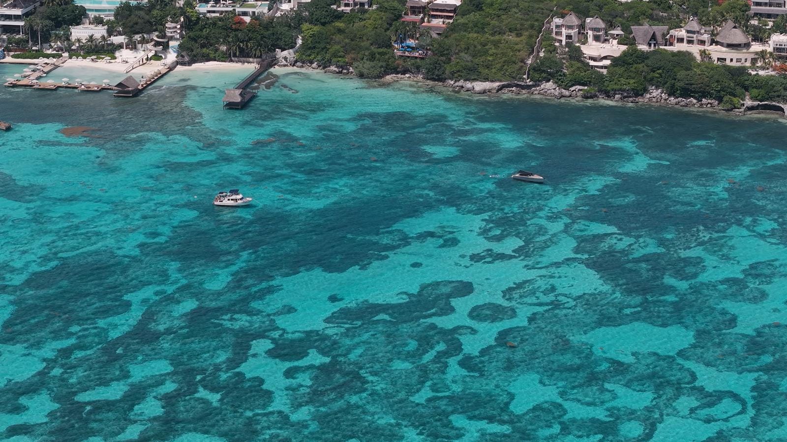 Aerial view of reef patches in the clear turquoise water off Isla Mujeres