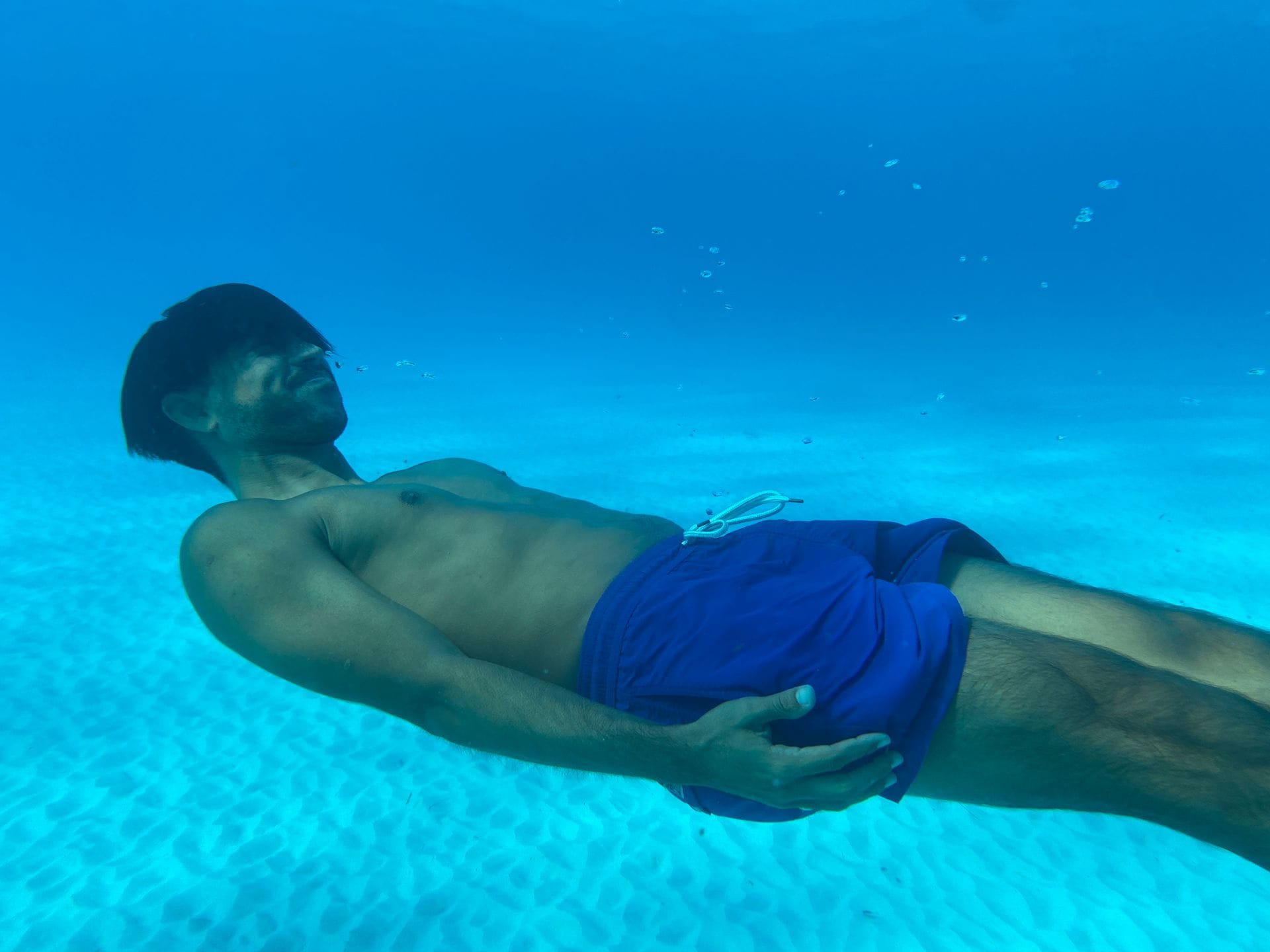 Guest floating on his back in the clear blue water of the Arenales