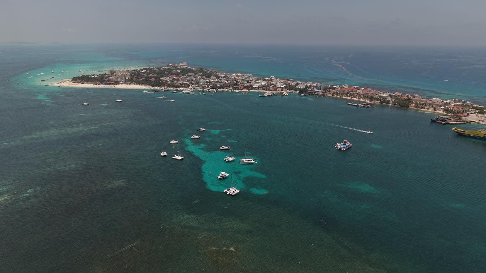 Aerial view of boats anchored in the turquoise shallows on the western side of Isla Mujeres