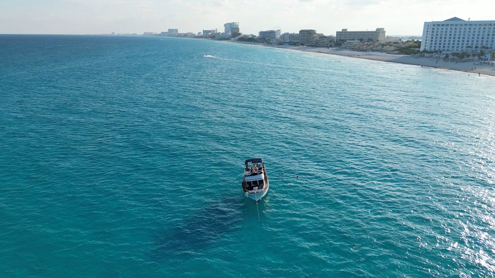 Aerial view of the Tafil in turquoise water with the Cancún hotels on the horizon