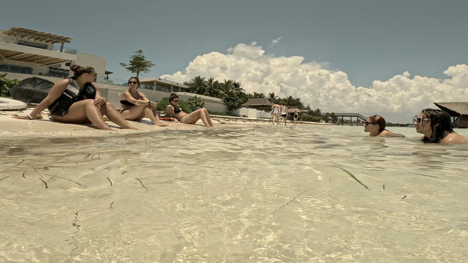 Palm-lined Presidente Beach with guests in the shallow water