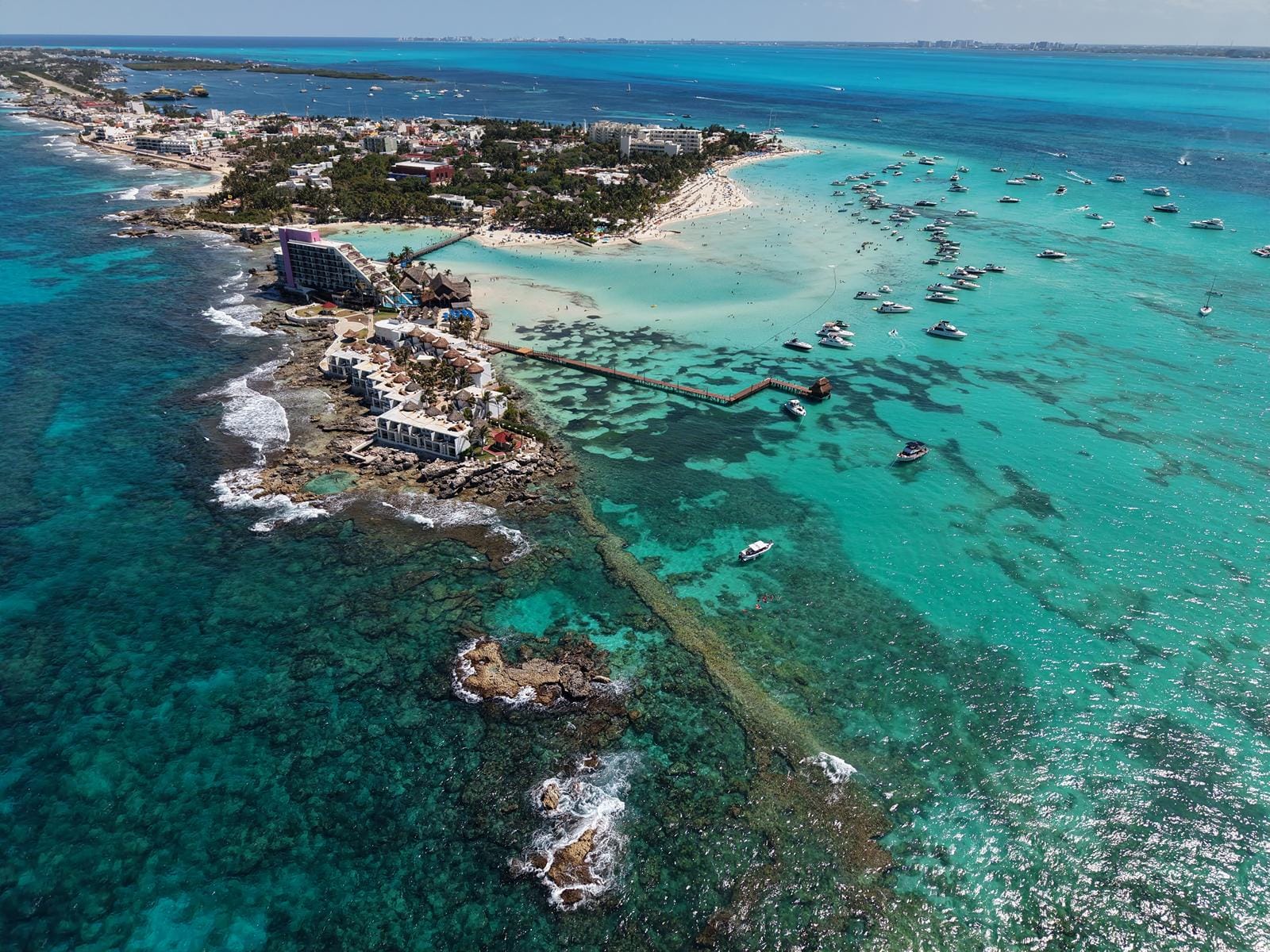Aerial view of the rocky point and reef at the tip of Isla Mujeres with boats anchored nearby