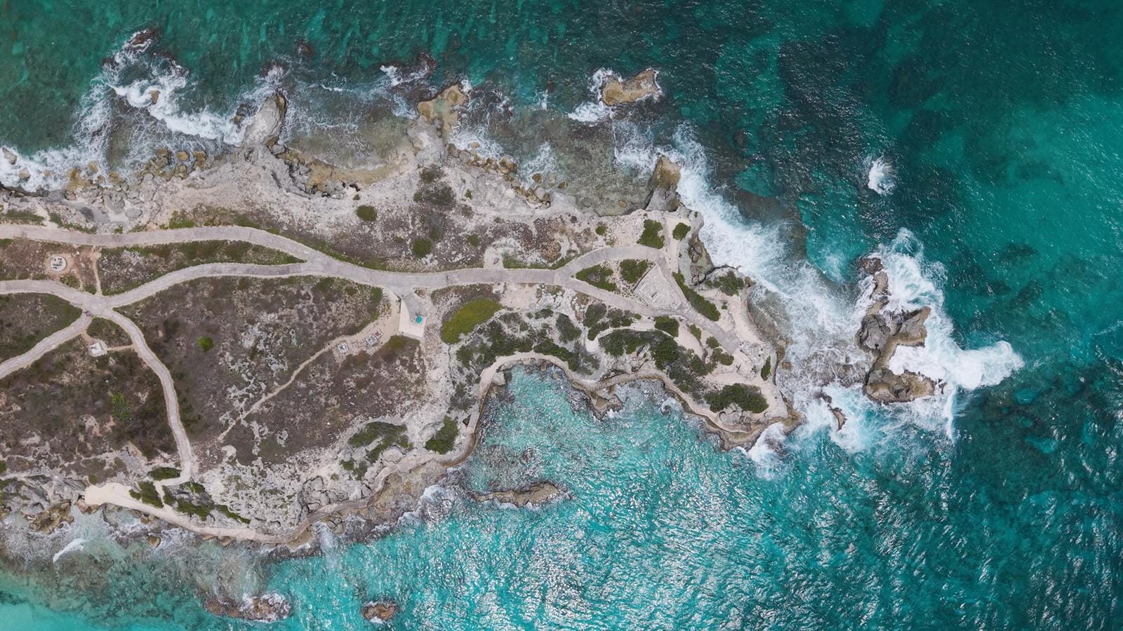 Top-down view of the rock formations at the tip of Punta Sur with waves breaking