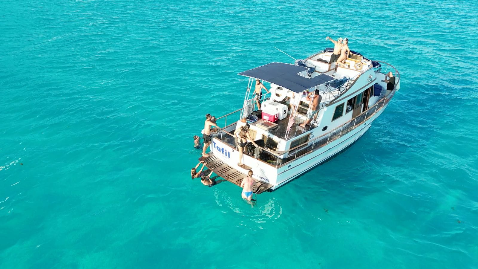The Tafil with guests aboard in the turquoise water off the Hotel Zone
